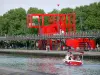 Parc de la Villette - Tour en bateau sur le canal de l'Ourcq ; Ateliers Villette et arbres du parc en arrière-plan