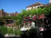 Saint-Cirq-Lapopie - Terrasse de restaurant, vigne, fleurs et maisons du village, dans la vallée du Lot, en Quercy