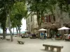 Cordes-sur-Ciel - Platz Bride mit seinen Steinbänken, seinen Bäumen, seiner Terrasse eines Restaurants, seinen Häusern aus Stein und seinem Aussichtspunkt auf die umliegenden Hügel