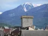 Embrun - Tour Brune (ancien donjon des archevêques) et toits de la vieille ville avec vue sur les montagnes aux cimes enneigées ; dans la vallée de la Durance