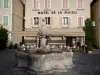 Embrun - Barthelon square: fountain, café terrace and facades of houses of the old town