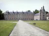 Fleury-en-Bière castle - Alley lined with lawns and facade of the château made of brick and stone
