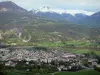 Hautes-Alpes Landschaften - Tal der Durance:Blick auf die Dächer der Altstadt von Embrun, den Fluss Durance gesäumt von Bäumen, die Wiesen und die Berge mit Gipfel bedeckt mit Schnee