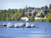 Joigny - An der Yonne festgemachte Boote und Häuser entlang des Wassers in einer grünen Umgebung