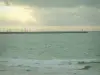 Küstengebiet der Loire-Atlantique - Meer (Atlantischer Ozean), Maste von Segelbooten, Leuchtturm und gewittriger Himmel mit Sonnenstrahlen