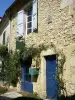 Lavardens - Gevel van een stenen huis met blauwe deuren