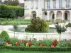 Meaux - Pond with a rock and flowerbeds in the Bossuet garden (French-style formal garden of the former bishop's palace) and facade of the former Episcopal palace in the background