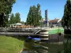 Melun - Banks of River Seine: moored barge with a terrace restaurant, River Seine, facades of the town and trees