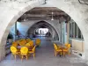 Monflanquin - Bastide médiévale : terrasse de café sous les arcades