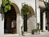 Monflanquin - Bastide médiévale : arcades de la place centrale agrémentées de fleurs