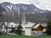 Névache - Bell tower of the Saint-Marcellin church and houses of the village, trees and snowy mountain (snow); in the Clarée valley