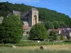 Saint-Amand-de-Coly - Igreja da abadia fortificada, casas da aldeia, fardos de palha num campo e árvores, em preto Périgord