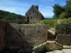 Saint-Amand-de-Coly - Remparts (recinto) da igreja da abadia e pequena casa de pedra, em preto Perigord