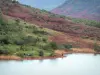 See Salagou - Rückhaltebecken, Ufer, rote Felsen, Bäume und Hügel