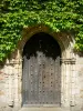Solesmes abbey - Saint-Pierre de Solesmes Benedictine abbey: wooden door of the abbey church topped with vine