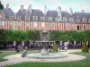 Vosges square - Fountain of the Louis XIII square, rows of trees and buildings facades of the former royal place; in the Marais district