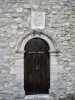 Old door, surmounted by a very degraded coat of arms (© J.E)