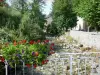 Авл-ле-Бен - Цветущий мост (цветы) через реку, деревья на краю воды и дома в деревне (курорт); в региональном природном парке Арьеж Пиренеи, в долине Гарбет