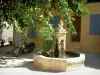 Гримо - Небольшая площадь с фонтаном и деревом, желтый дом на заднем плане