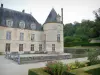 Замок Бюсси-Рабютин - Цветочная клумба французского сада с видом на ров, фасад жилого корпуса и одну из круглых башен замка