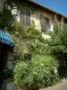 Ле-Кастелле - Цветущие кусты, вьющиеся растения, фонарный столб и дом средневековой деревни
