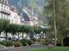 Ле-Мон-Дор - Спа: парк с деревьями и фасадами домов; в Региональном природном парке вулканов Овернь, в горах Доре