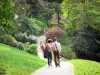 Парк Бют-Шомон - Пара пешеходов прогуливается по наклонной дороге ландшафтного парка