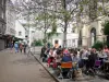 Улица Скунса - Ресторан Терраса Рю Муффетард в тени деревьев и фасад церкви Сен-Медар