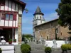 Ainhoa - Iglesia de Nuestra Señora de la Asunción, con su torre cuadrada con cuatro pisos, cementerio y casa de pueblo vasco rojo enmaderado