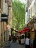 Aix-en-Provence - Ruelle bordée de maisons et boutiques, platanes en arrière-plan