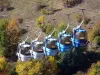 Alpe d'Huez - Канатная дорога (подъемник) зимнего и летнего спортивного курорта (горнолыжный курорт), деревья внизу в цветах осени