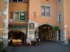 Annecy - Casas com arcadas com fachadas coloridas, terraço de um restaurante e loja