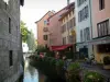 Annecy - Île Palace (former prisons), the Thiou canal, flower-bedecked bank, restaurants and houses with colourful facades