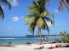 Anse-Bertrand - Beach of the Chapel with its palm trees, its white sand and its view of the Caribbean sea and the town of Anse-Bertrand; on the island of Grande-Terre
