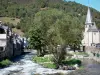 Arreau - Saint-Exupère chapel and houses of the village along the river, trees; in the Bigorre area