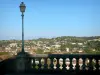 Auch - Farola y la barandilla de la escalera en el primer plano, con vistas al valle del Gers y los tejados de la ciudad baja