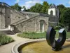 Auvers-sur-Oise - Parque del castillo de Auvers con estanque decorado con una escultura moderna y escaleras que conducen al castillo