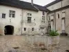 Baume-les-Messieurs - Abbaye : fontaine de la cour du cloître, bâtiment abbatial, passage voûté et église abbatiale Saint-Pierre