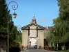 Bergues - Puerta de Cassel, las campanas de la espadaña en el fondo, los árboles y postes de luz