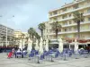 Canet-en-Roussillon - Café terrace, palm trees and building facades of the resort