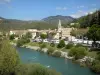 Castellane - Verdon river, bell tower of the Saint-Victor church, houses of the old town and mountains; in the Verdon Regional Nature Park