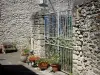 Castelmoron-d'Albret - Puerta de jardín, paredes de piedra y macetas