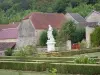 Castillo de Bussy-Rabutin - Estatua y macizos de flores del jardín francés.