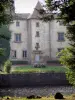 Castillo de Les Martinanches - Escalera de la torre y la fachada del castillo, jardín de flores, los fosos y los árboles en la ciudad de Saint-Dier-d'Auvergne, en el Parque Natural Regional Livradois