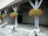 Charroux - Salón de columnas de madera adornada con geranios (flores)