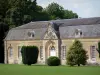 Château du Bourg-Saint-Léonard - Outbuilding of the château, lawn and trees; in the town of Le Bourg-Saint-Léonard