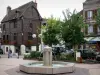 Château-Renard - Plaza de la República, con una fuente, donde Juana de Arco (antigua casa de entramado), árboles, flores y casas en la ciudad