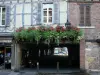 Châtillon-sur-Chalaronne - Facade of a timber-framed house, and flower-bedecked entrance of the covered market hall 