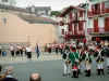 Ciboure - Casas blancas con contraventanas rojas de la ciudad vieja y frontón acoger un espectáculo de música tradicional