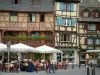 Colmar - Marcos de madera y casas con tiendas y cafetería con terraza